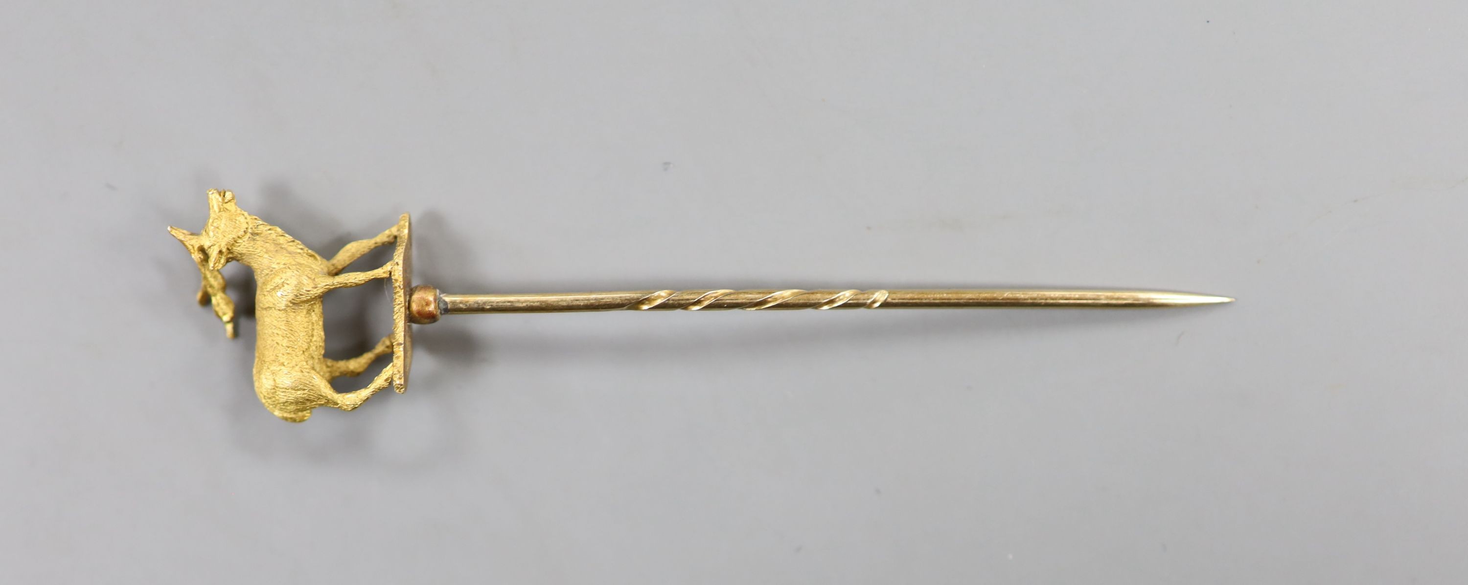 A cased early 20th century yellow metal stag stick pin, 77mm, 4.3 grams (a.f.).